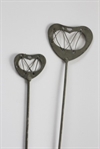 2 stk. Solide grå metal hjerter. På metal pind. Hjerterne måler ca.  6 og 4 cm. Flade hjerter.